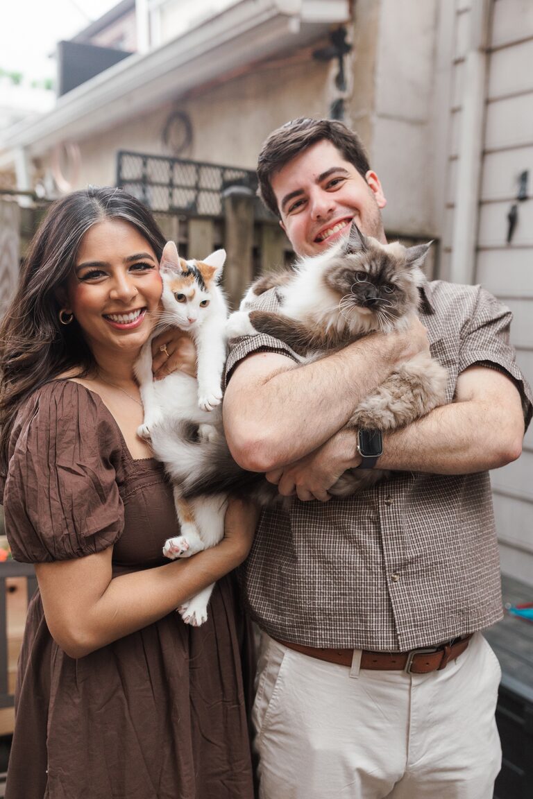 Anika and Louis holding Mishti, a seal-point Siberian cat, and Ruthie, a white-and-orange calico